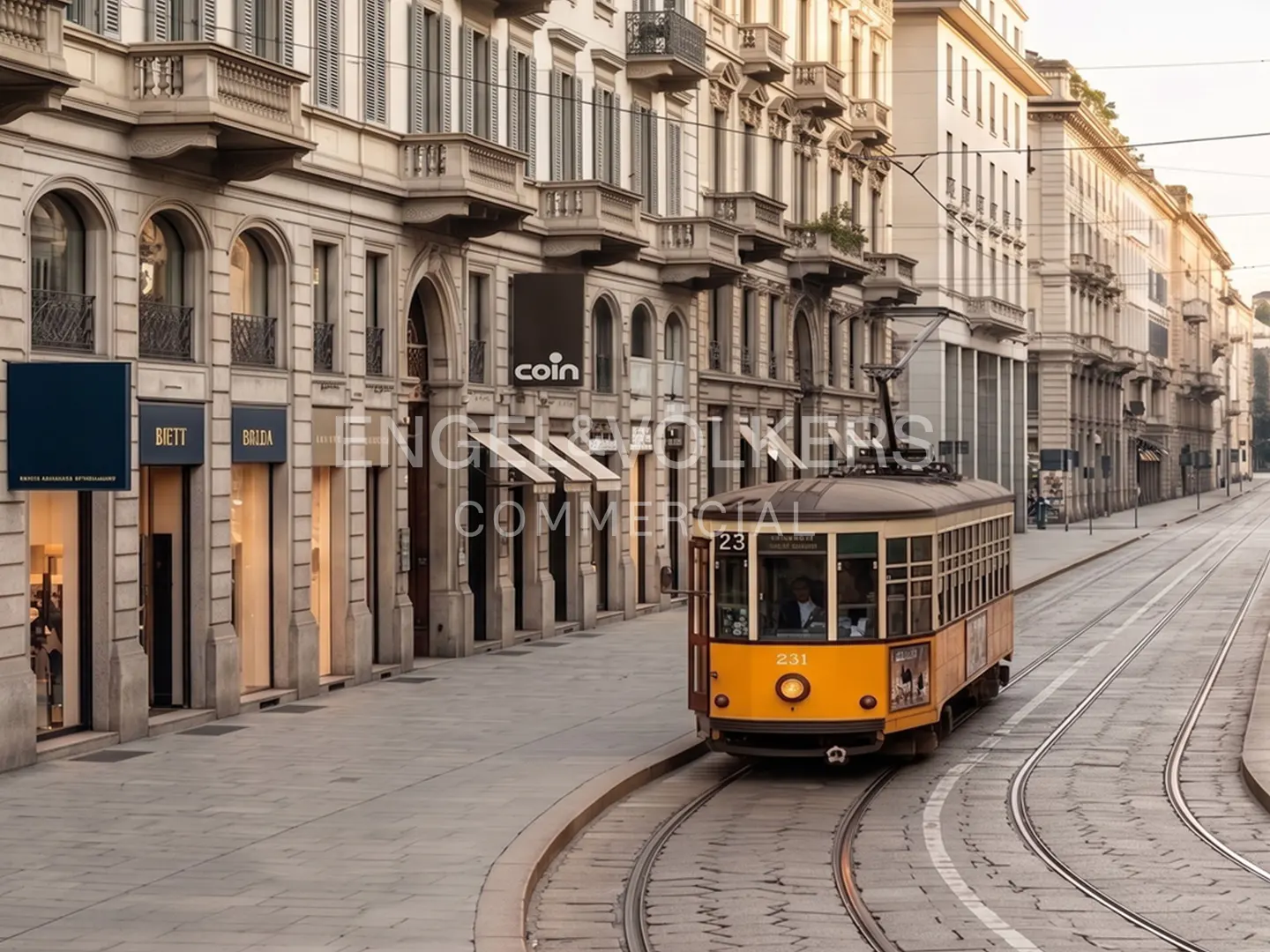 A yellow tram travels down a city street lined with shops and apartments.