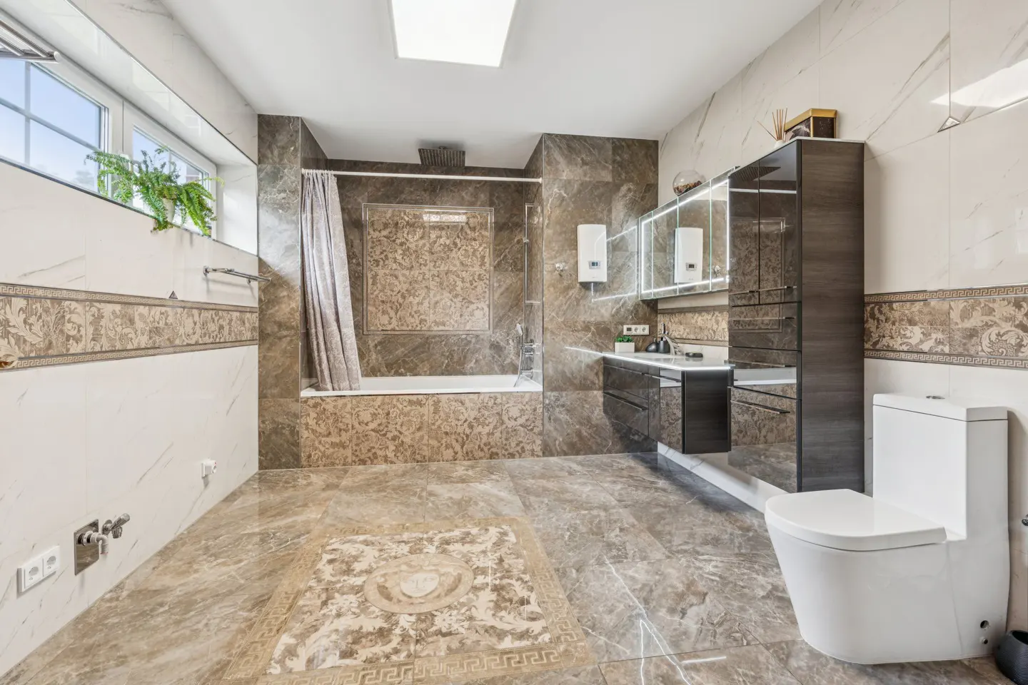 A modern bathroom with marble floors, a white toilet, a dark vanity, and a tub with a shower curtain.