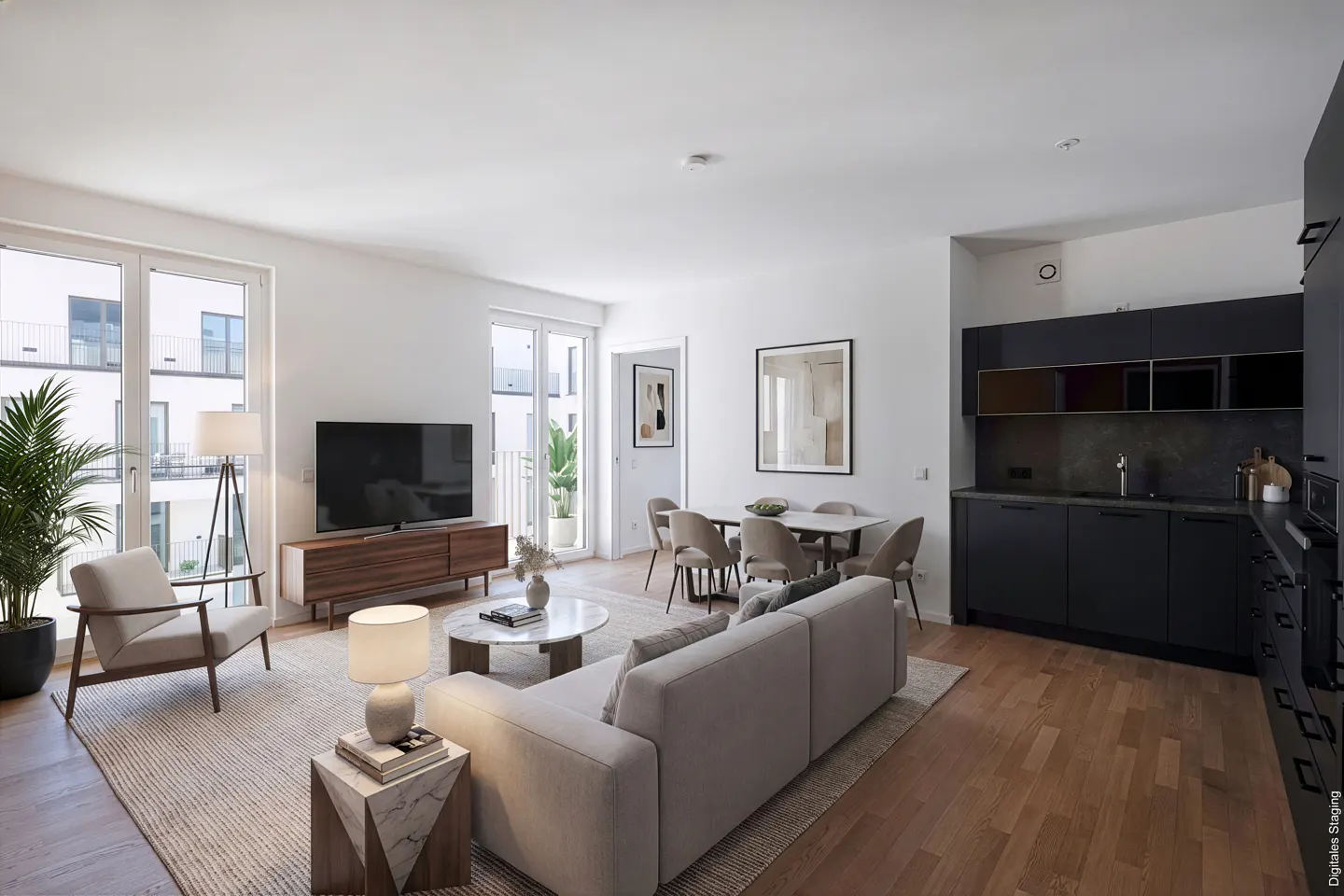 Bright, modern apartment interior with a beige sofa, dining table, dark kitchen cabinets, and wood floors. Large windows offer natural light.