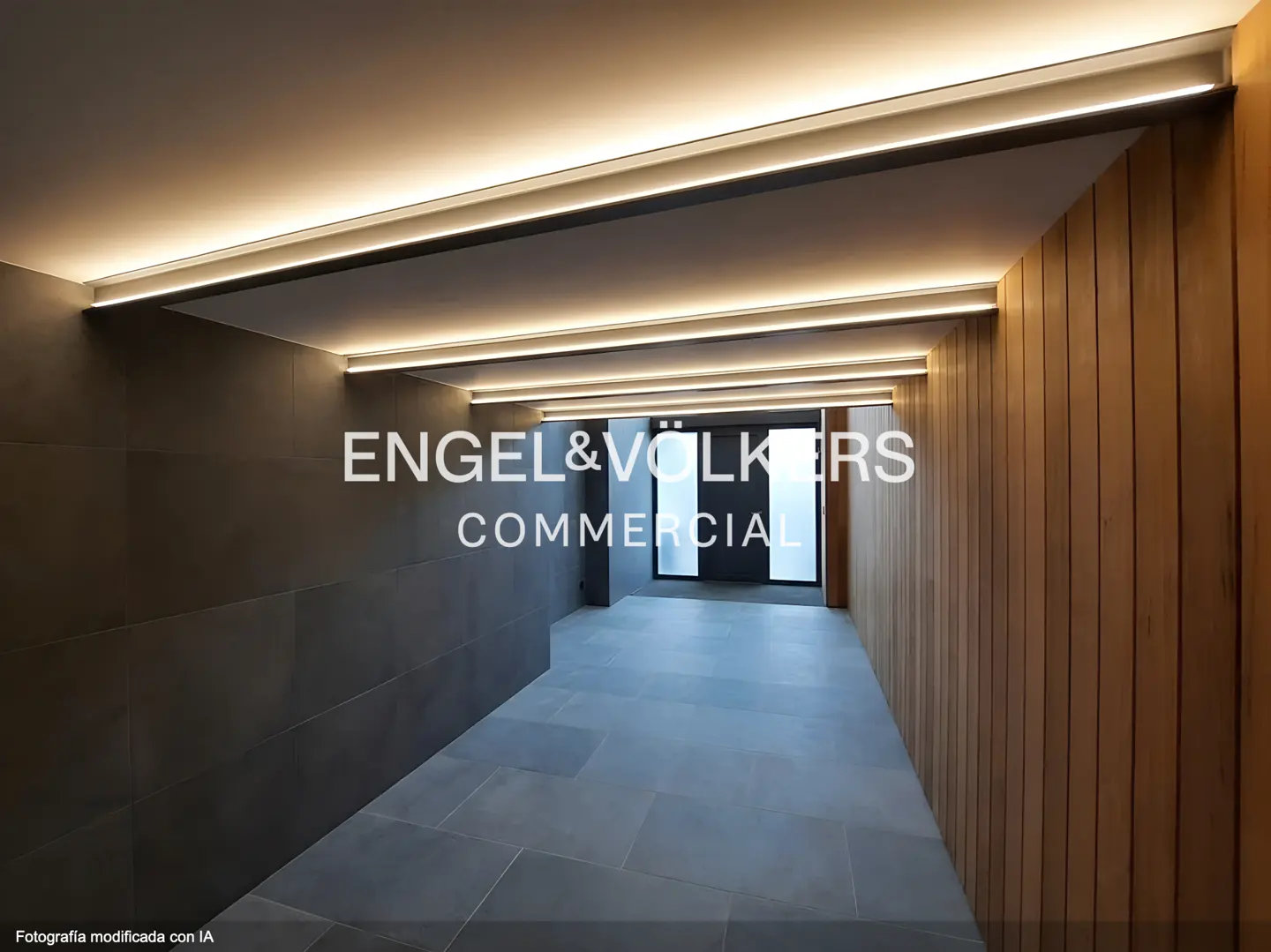 Hallway with gray tile floor, wood panel wall, and LED strip lighting. Engel & Völkers Commercial logo is superimposed.