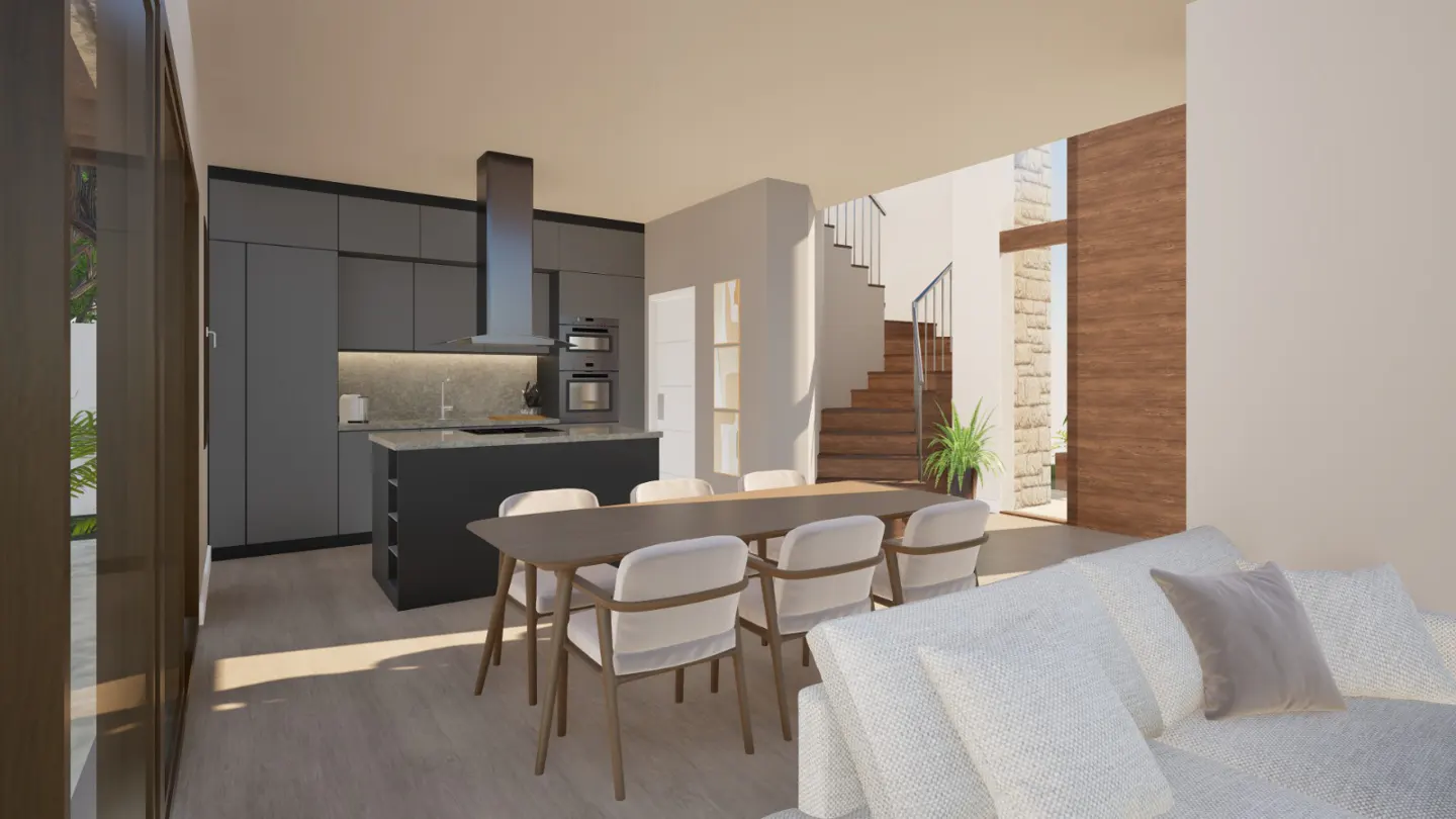 Open-concept living space with gray kitchen cabinets, a dining table with six chairs, and a white sofa. Stairs are visible in the background.