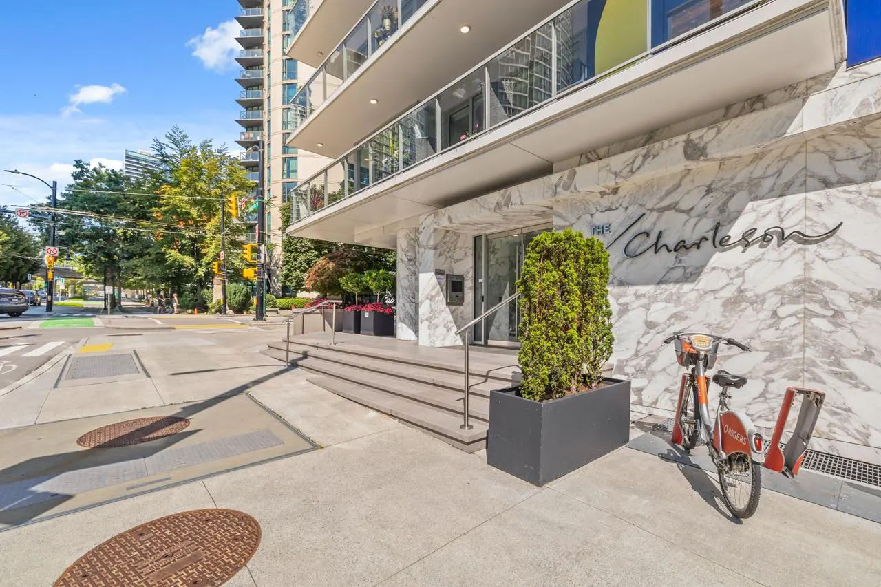 Exterior view of "The Charleson" building with marble facade, steps to entrance, and a rental bike parked nearby.