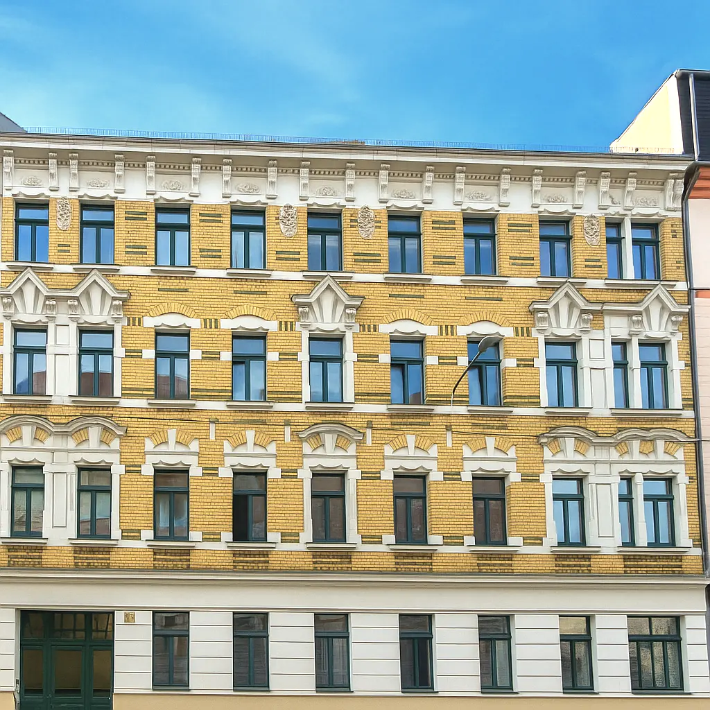 A yellow brick apartment building with dark green window frames under a blue sky.