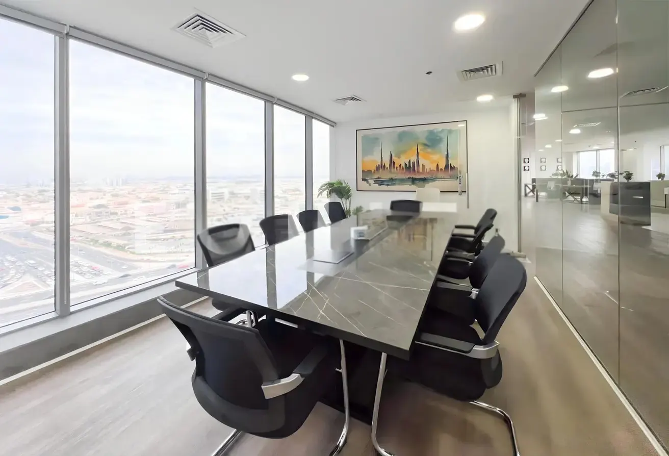 Conference room with a long marble table, black chairs, and a cityscape view through large windows. An abstract painting hangs on the wall.