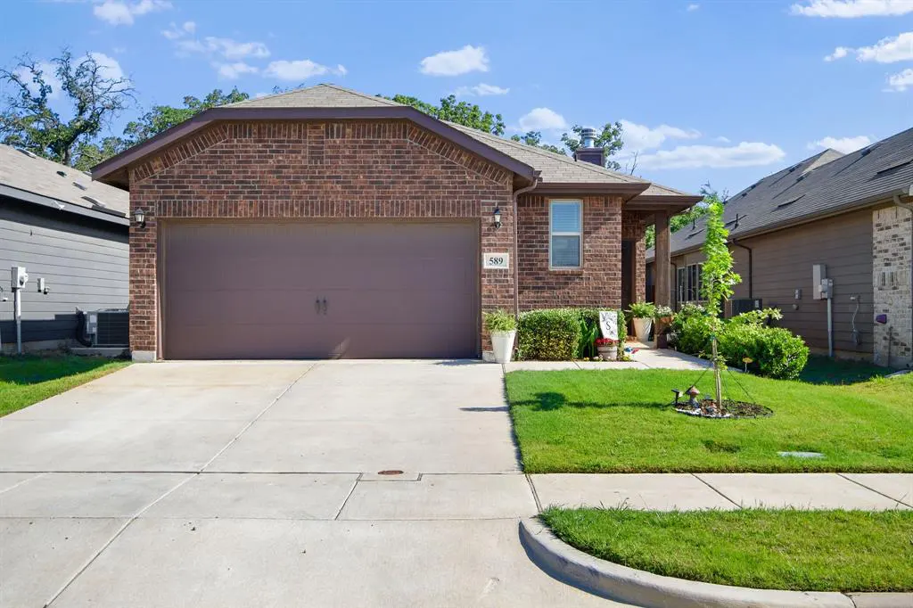 A single-story brick house with a brown garage door and a concrete driveway on a sunny day.