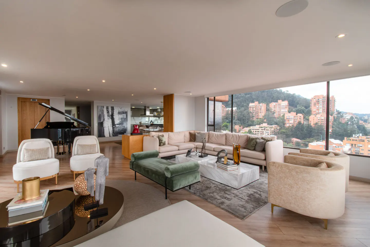 Spacious living room with a piano, beige sectional sofa, and city views through large windows.