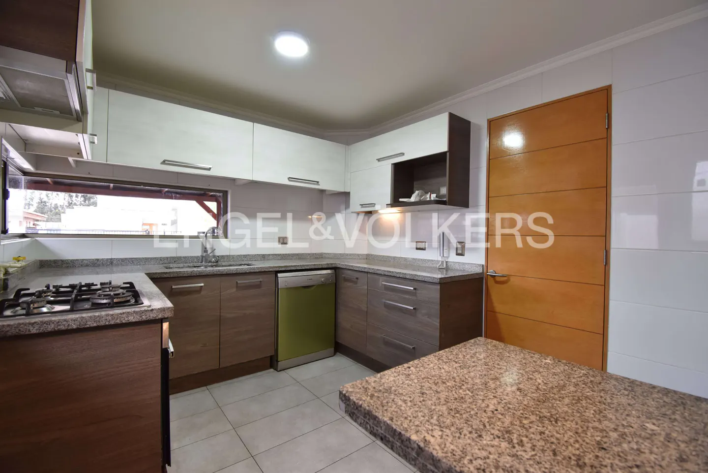 A modern kitchen with white cabinets, brown lower cabinets, a green dishwasher, and a granite countertop island.