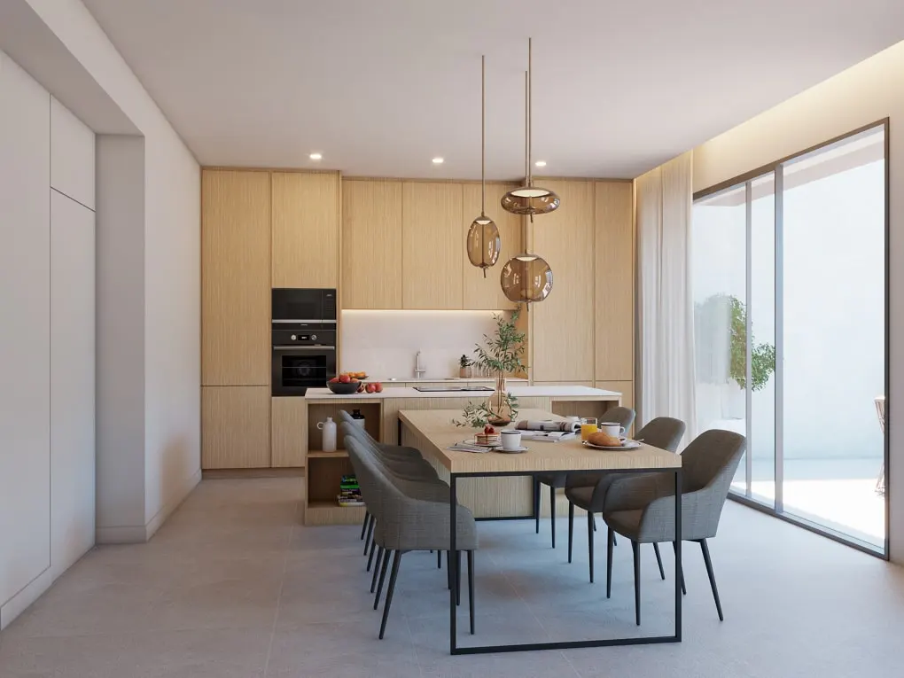 A modern kitchen and dining area with light wood cabinets, a black oven, and a long wooden table with gray chairs. Three pendant lights hang above the table. Sliding glass doors lead to an outdoor patio.
