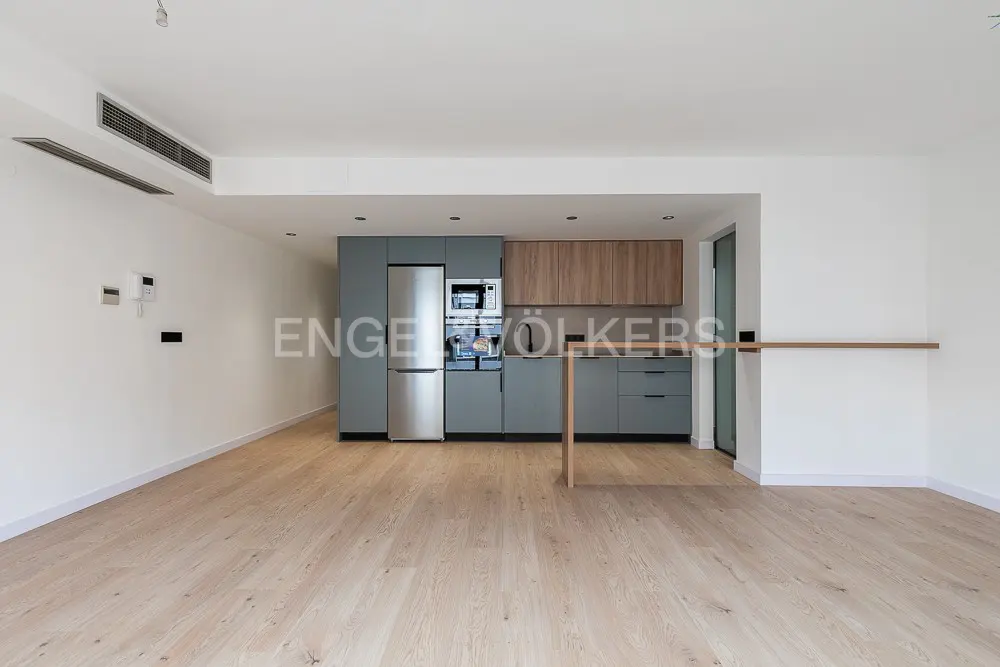 Modern kitchen with grey cabinets, wood-tone upper cupboards, stainless steel appliances, and light wood flooring.