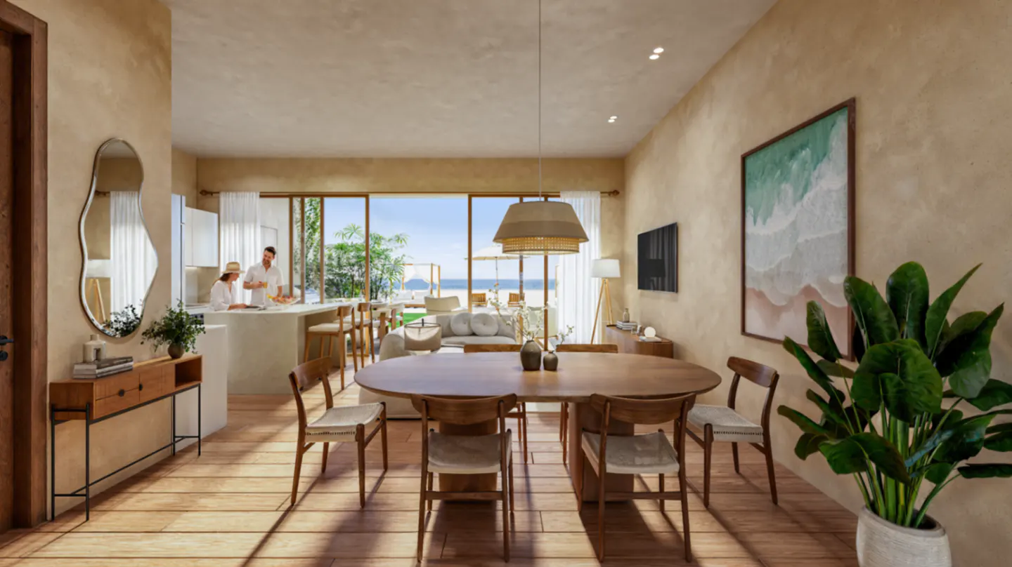 Open-concept living space with wood floors, dining table, and ocean view. People are in the kitchen. Neutral tones and natural light.