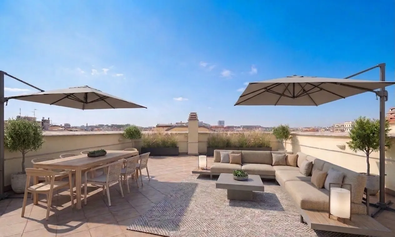 Outdoor rooftop patio with dining table, sofa, umbrellas, and city views under a clear blue sky.