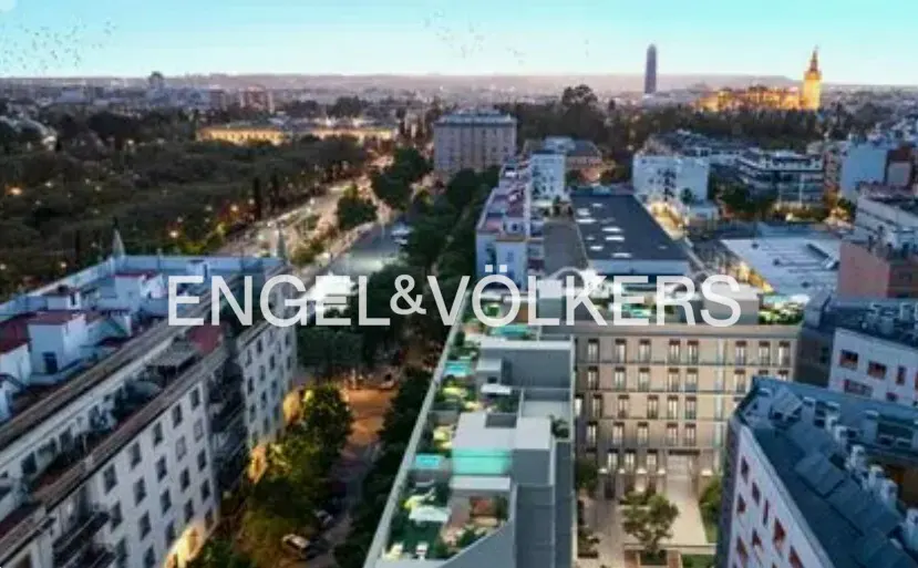 Aerial view of a city with buildings, trees, and the Engel & Völkers logo.