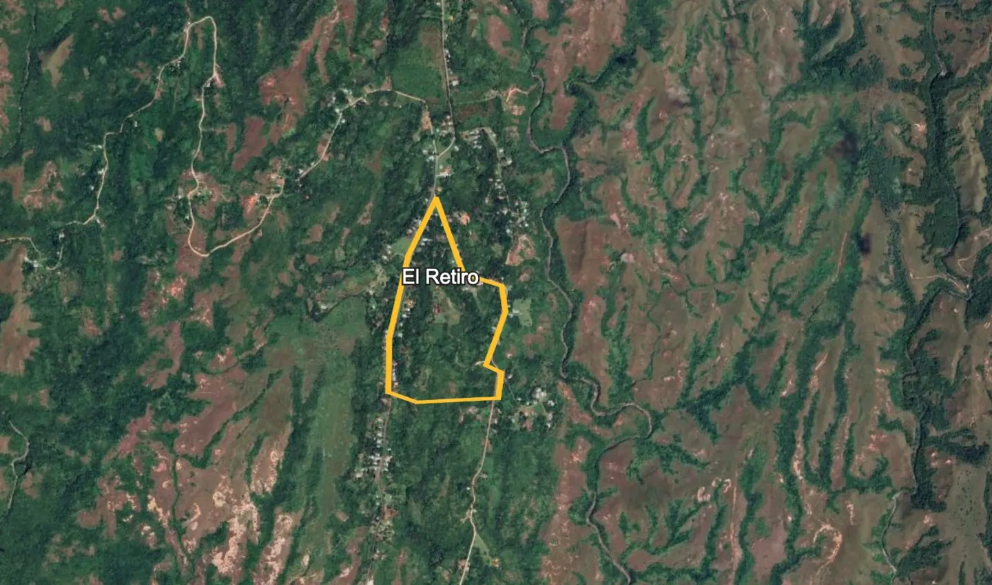 Aerial view of El Retiro, Belize, surrounded by lush green forest. A yellow outline marks the property's boundary.