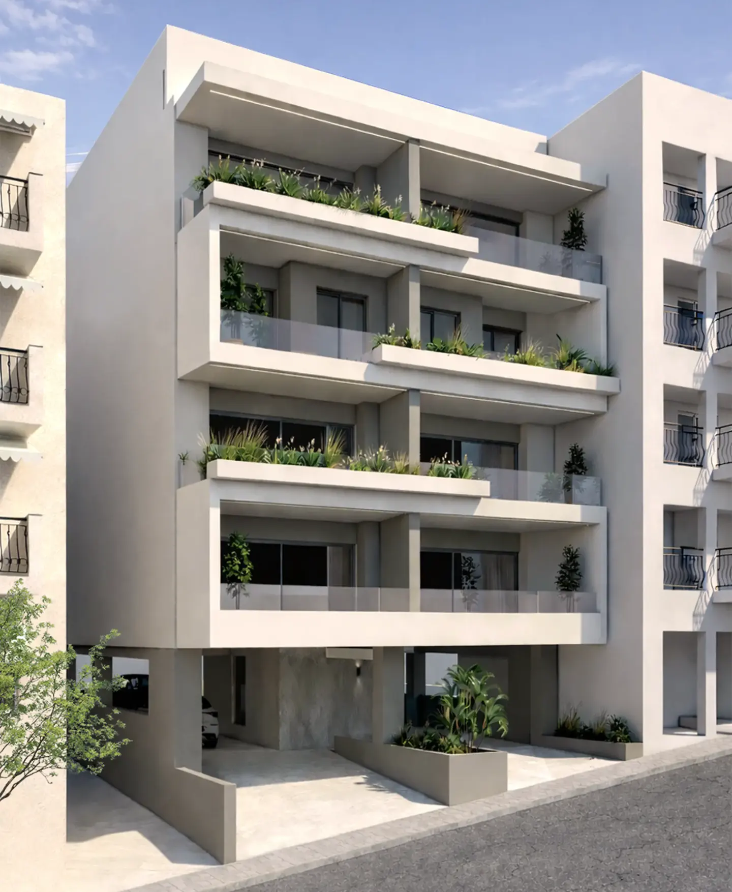 Modern, multi-story white apartment building with balconies and greenery. Parking is visible on the ground floor.