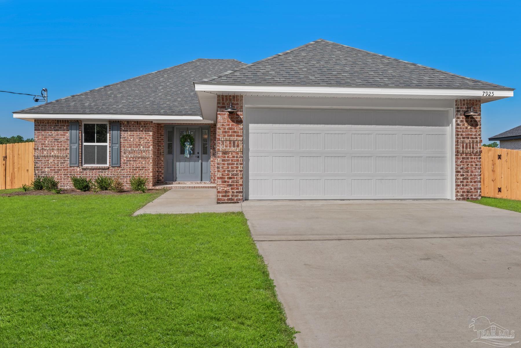 A single-story brick house with a gray roof, white garage door, and green lawn under a blue sky.