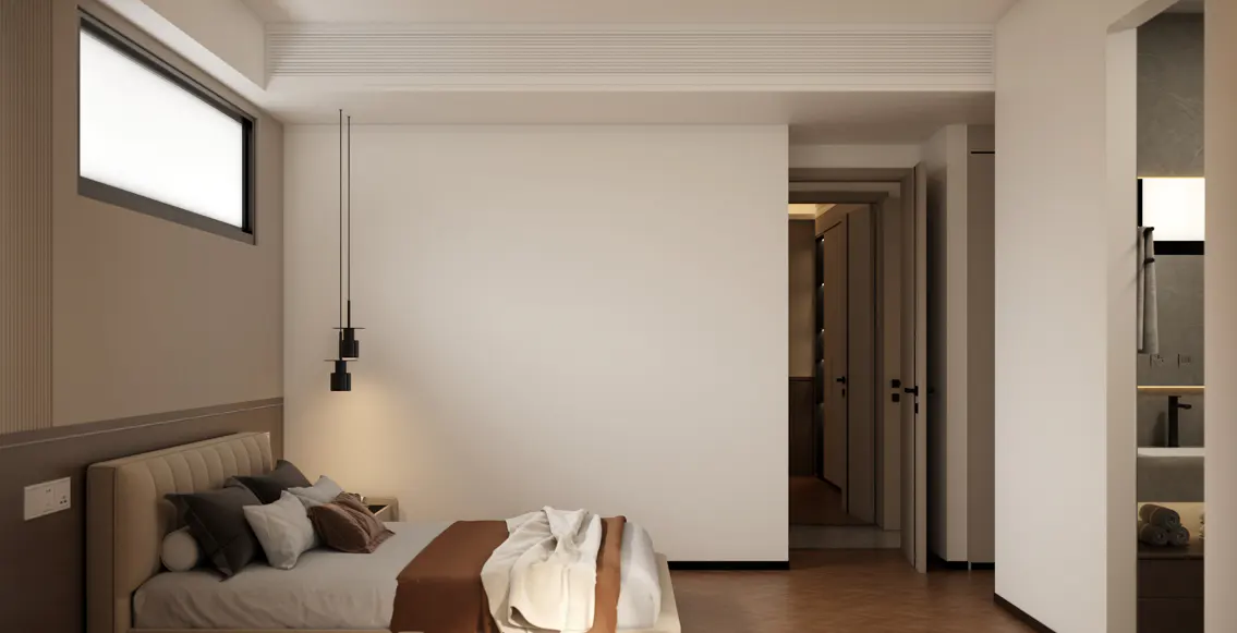 Bedroom with a beige upholstered bed, brown throw, and black pendant light. A hallway leads to a bathroom.