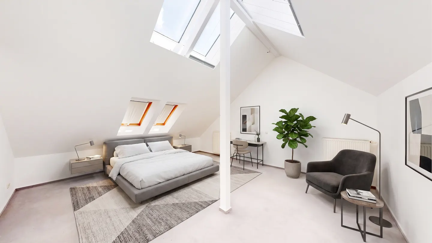 Bright attic bedroom with white walls, skylights, and gray furniture. A desk, chair, plant, and armchair complete the modern space.
