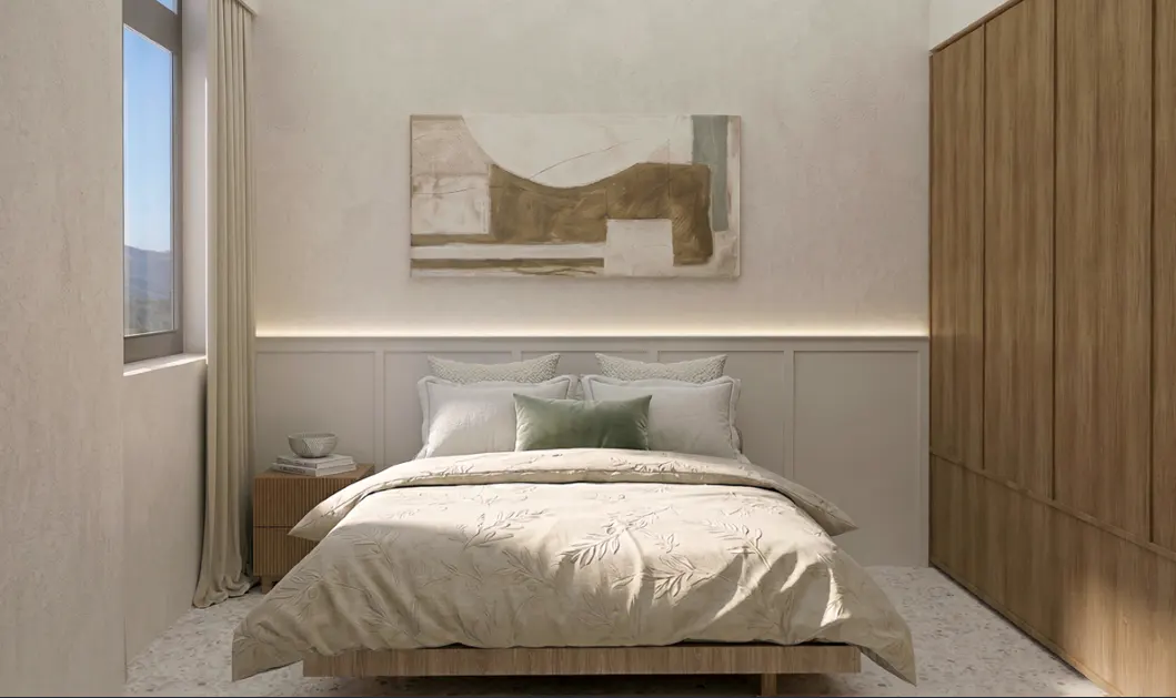 Bedroom with a bed, white bedding, and a green pillow. An abstract painting hangs above the bed. A wooden wardrobe is on the right.