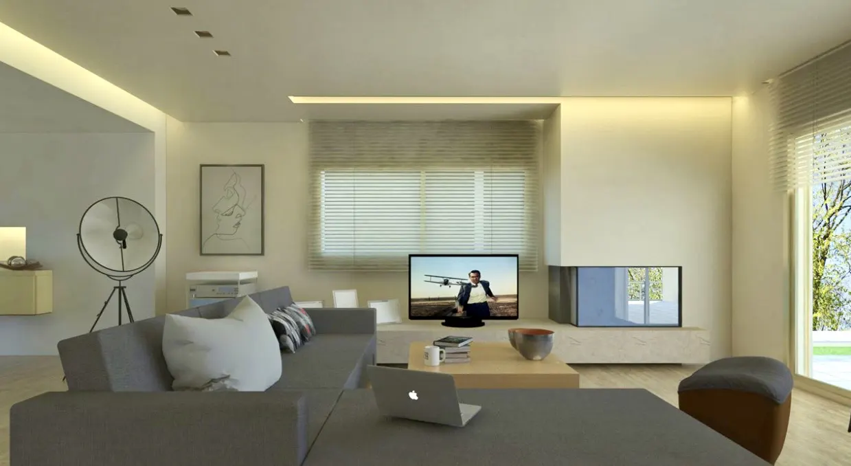 Modern living room with a grey sectional sofa, coffee table, laptop, television, and a tripod floor lamp.