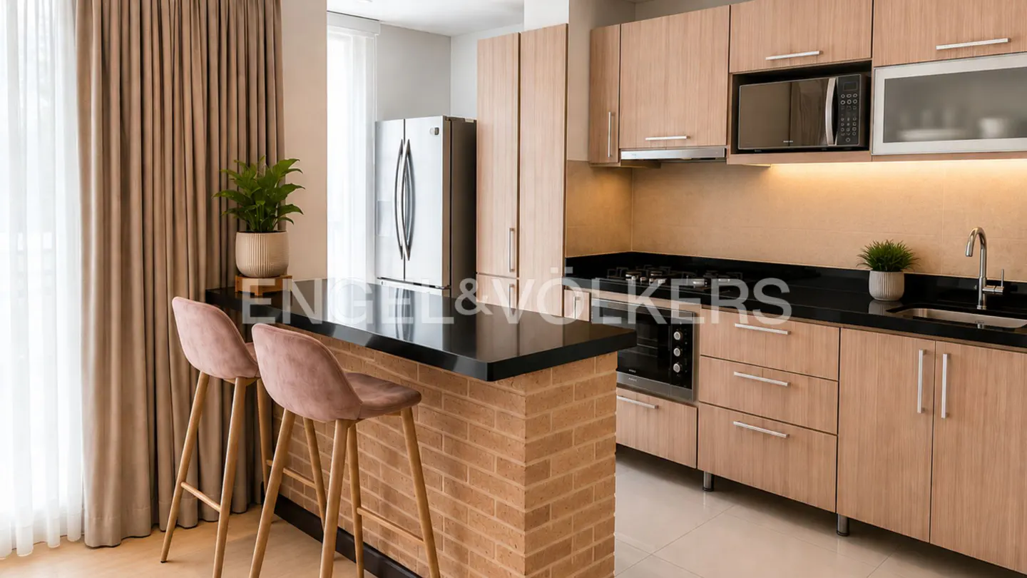 Modern kitchen with light wood cabinets, black countertops, brick breakfast bar, and two pink velvet bar stools.