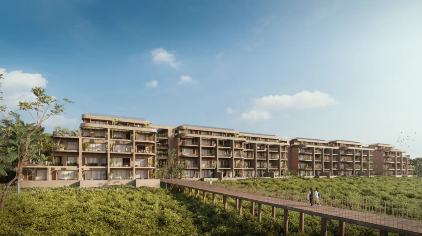 Modern multi-story apartment complex with balconies overlooking a lush green landscape and a wooden walkway.