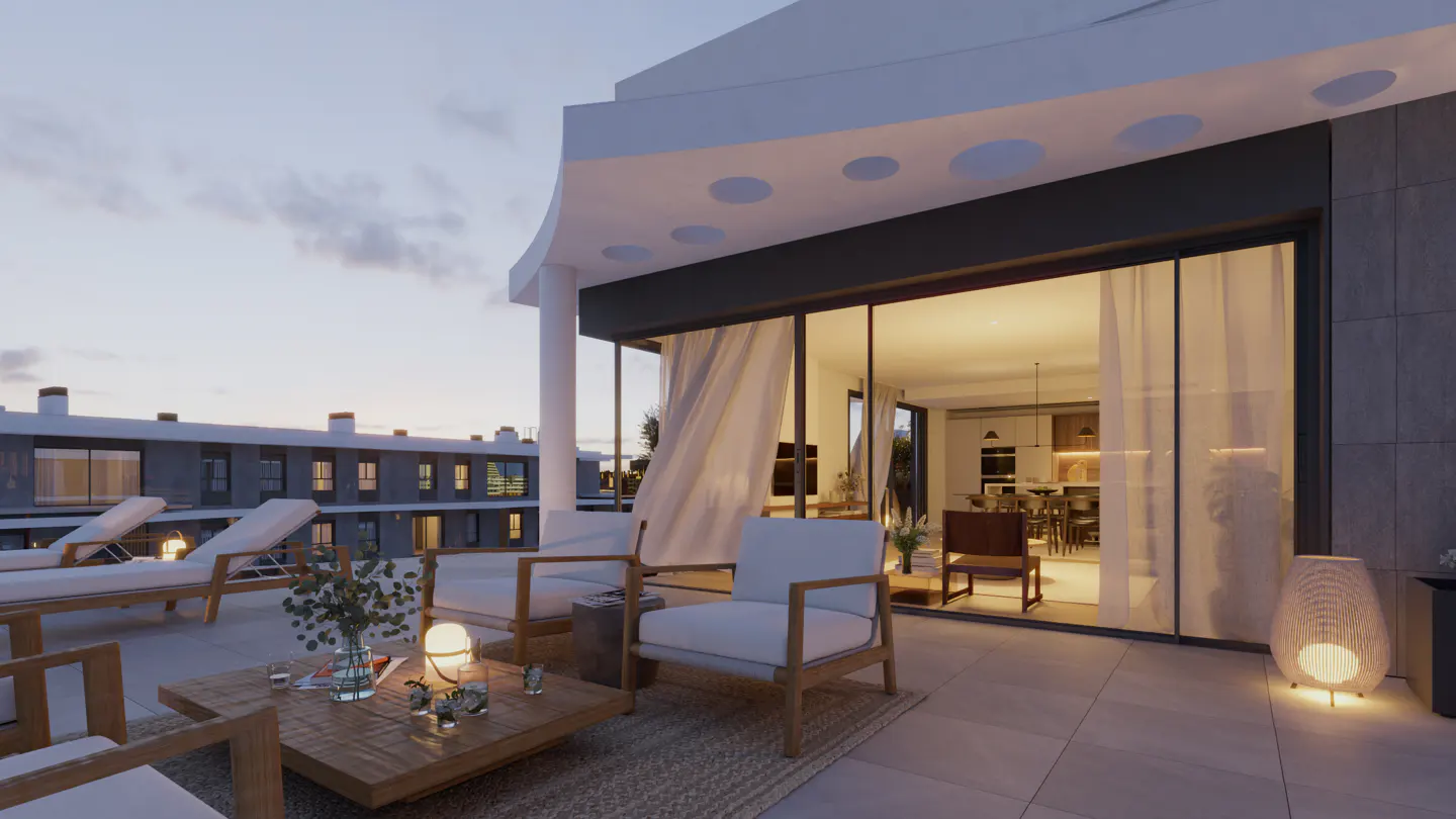 Outdoor patio with lounge chairs, table, and seating area. Sliding glass doors lead to a modern kitchen. Evening sky in the background.