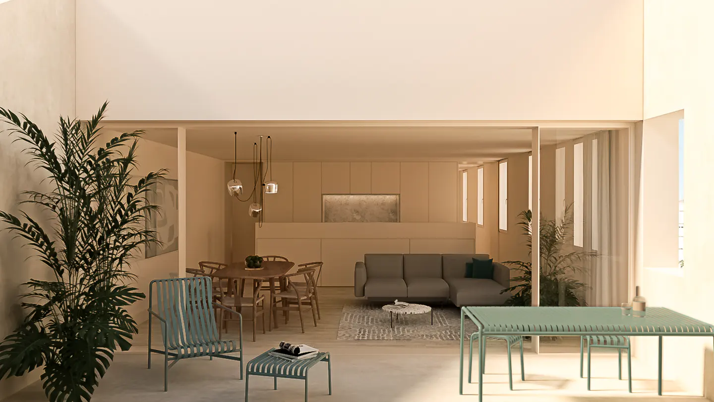 Open-concept living space with dining table, gray sofa, and green outdoor furniture. Large potted plant in foreground.