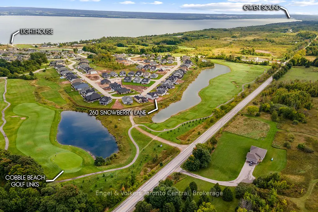 Aerial view of 260 Snowberry Lane, a house near Cobble Beach Golf Links, a lighthouse, and Owen Sound.