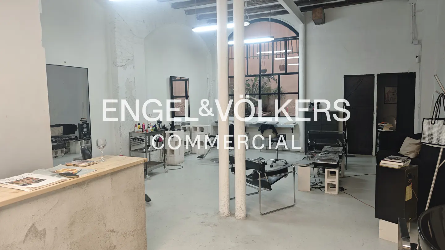 Bright, open commercial space with white walls, concrete floors, and tall windows. Salon chairs and equipment are visible. Engel & Völkers logo overlay.