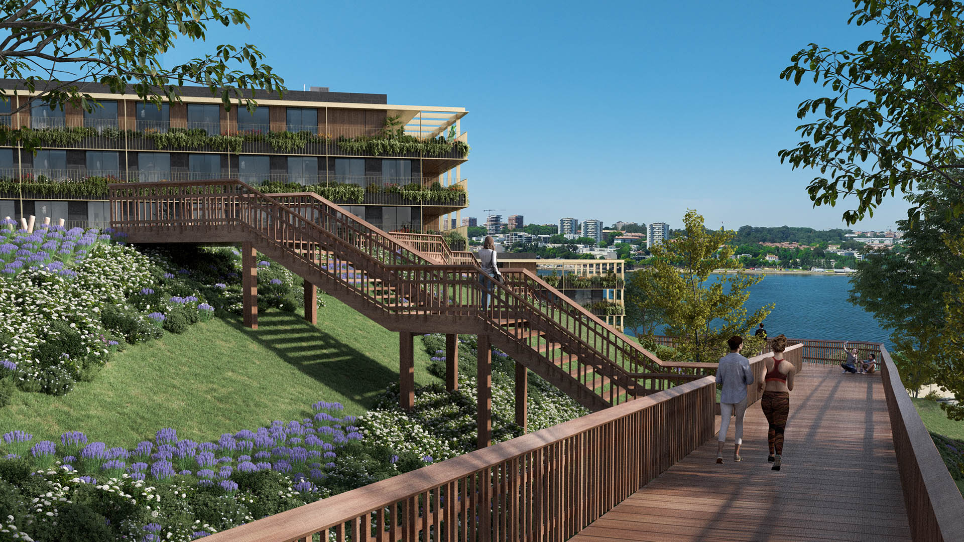 A wooden staircase leads to a modern building with greenery, overlooking a lake and city skyline on a sunny day.
