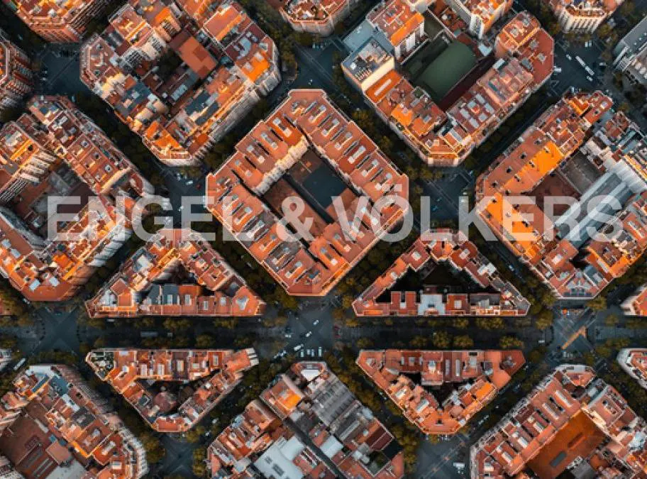 Aerial view of Barcelona's Eixample district, featuring orange-roofed buildings and the Engel & Völkers logo.