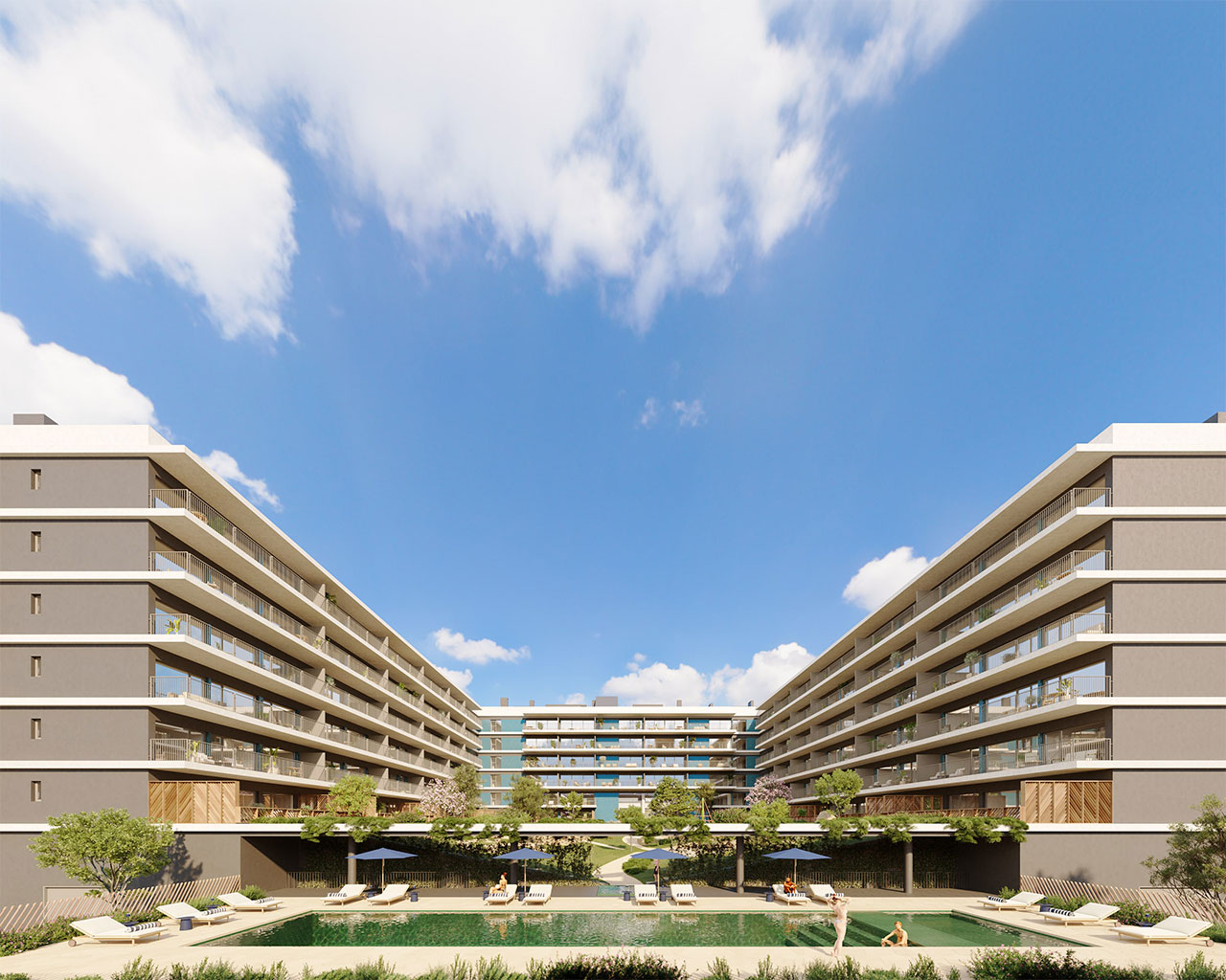 Exterior view of a modern apartment complex with a pool and lounge chairs under a blue sky.