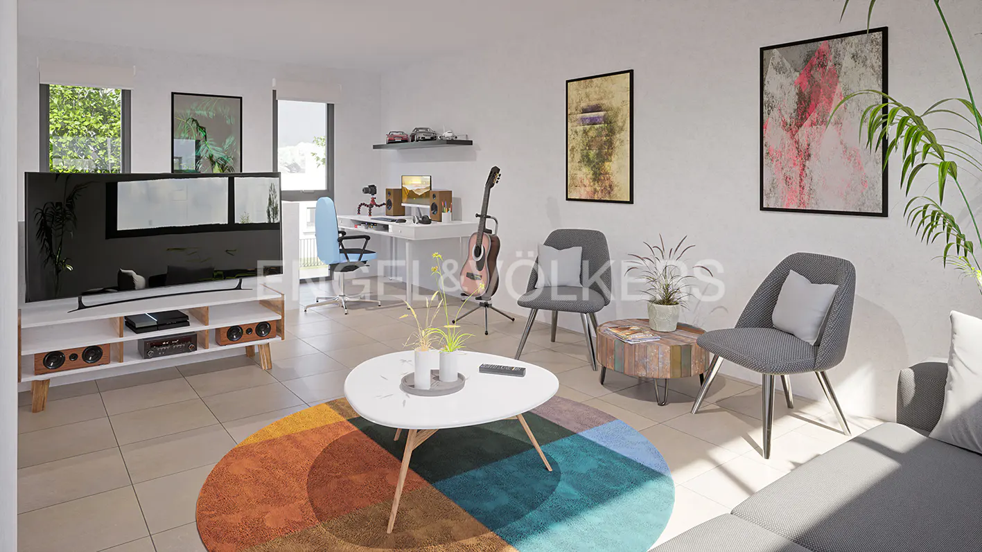 Living room with a TV, white media console, round rug, white coffee table, gray chairs, and a desk in the background.