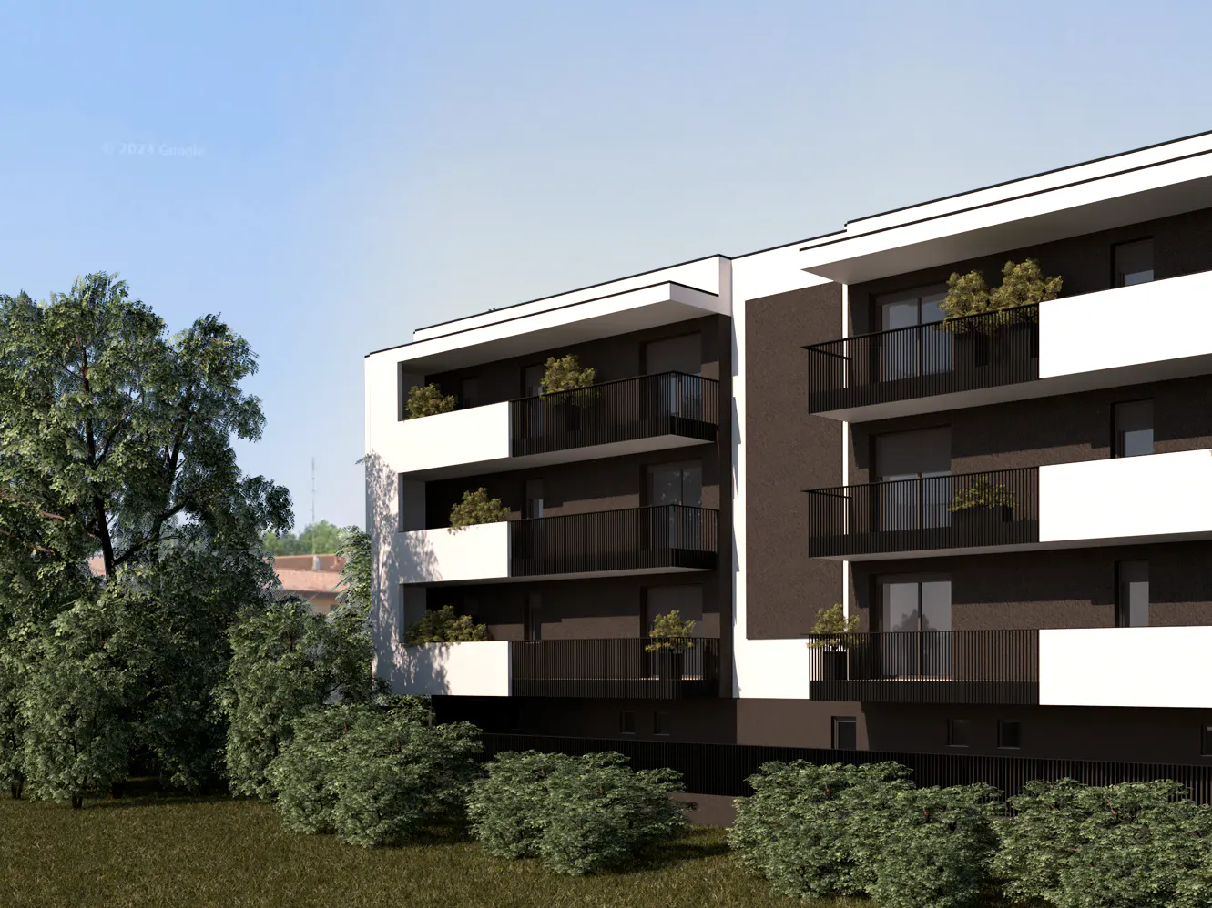 Modern apartment building with black balconies and white accents, surrounded by green trees and bushes.