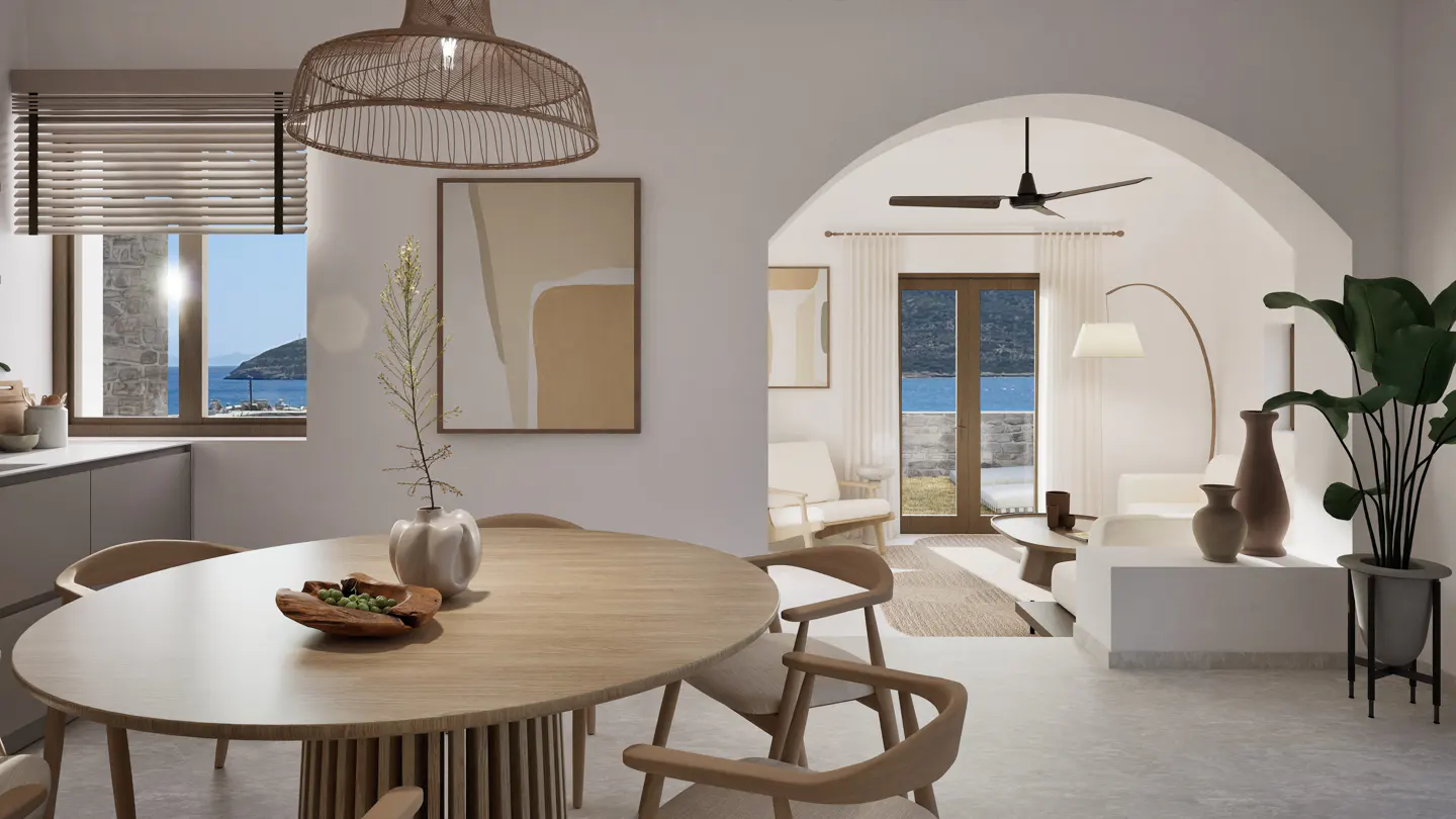 Bright, airy dining and living space with a round wooden table, chairs, and ocean view through an arched doorway.