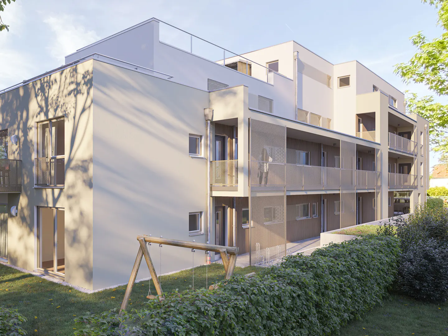 Modern beige apartment building with balconies, glass railings, and a wooden swing set in a grassy yard with hedges.
