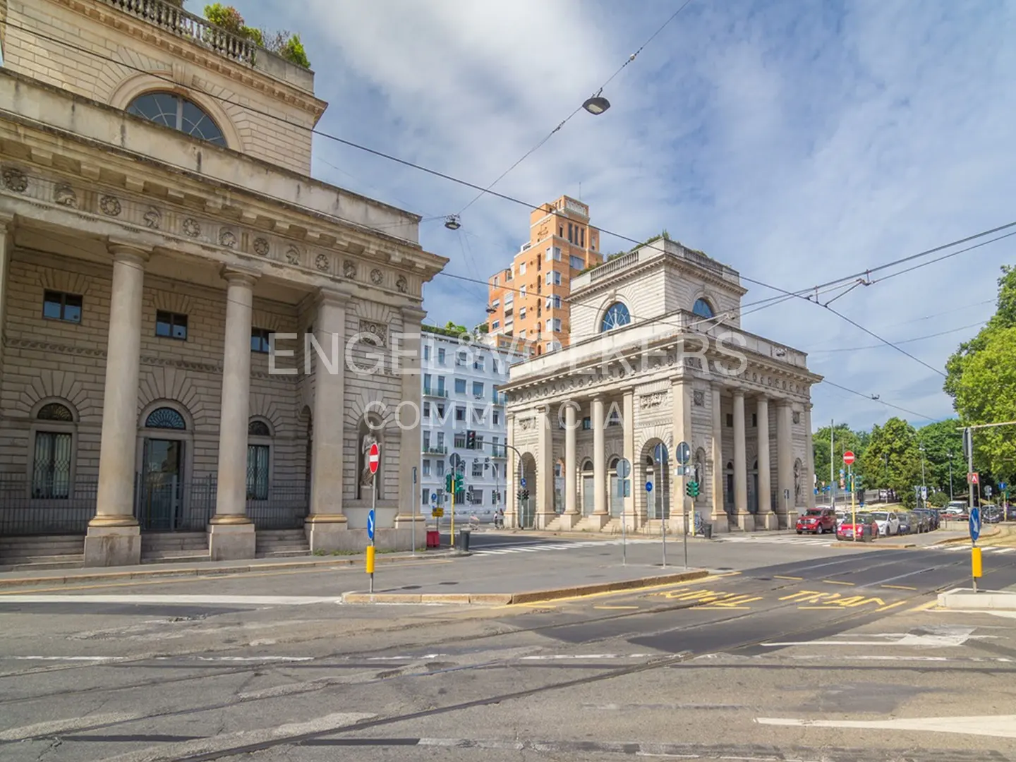Cityscape view of Porta Venezia in Milan, Italy, featuring neoclassical buildings with columns and arched windows on a sunny day.