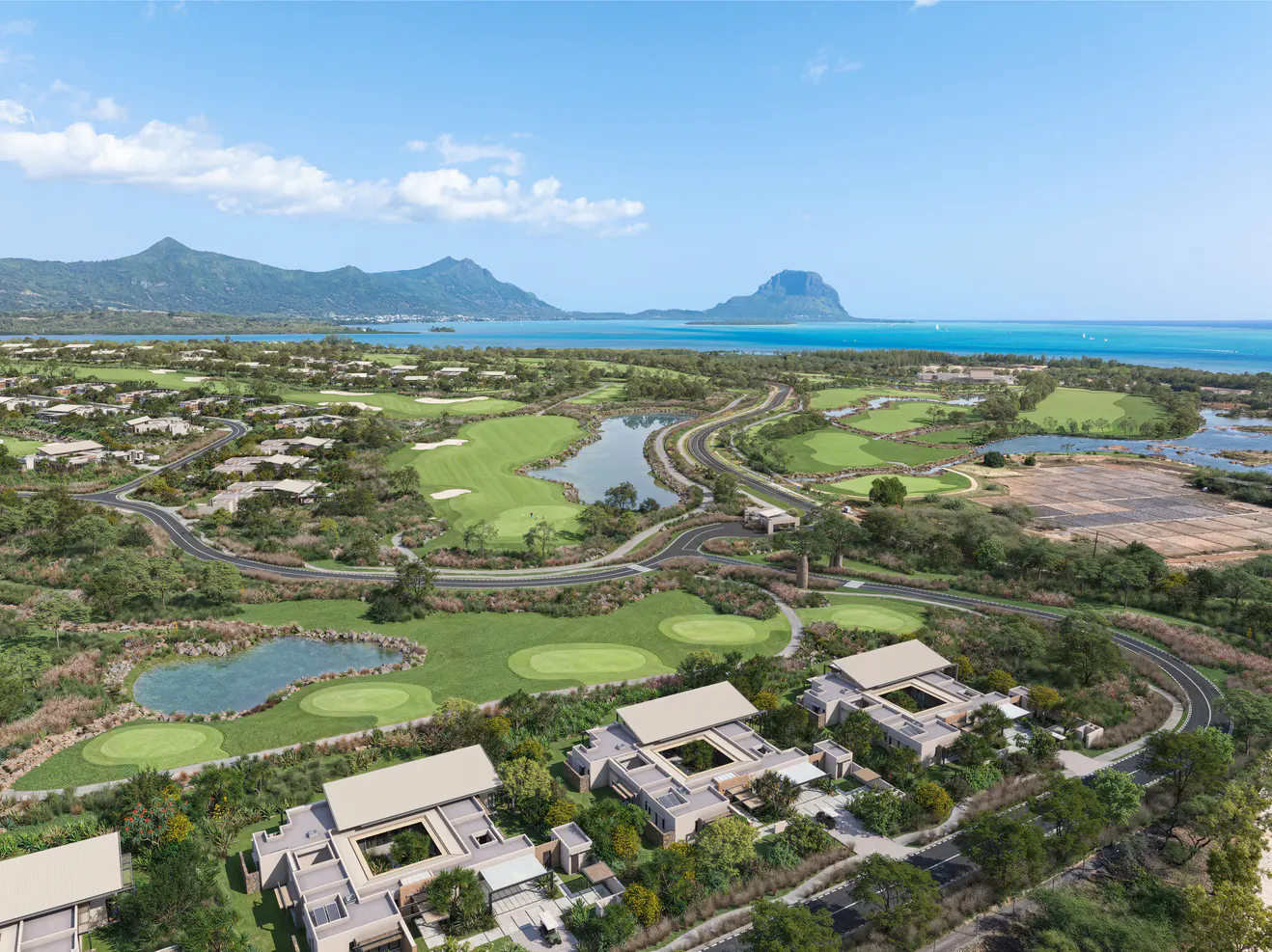 Aerial view of a luxury resort with a golf course, villas, and ocean backdrop under a blue sky.