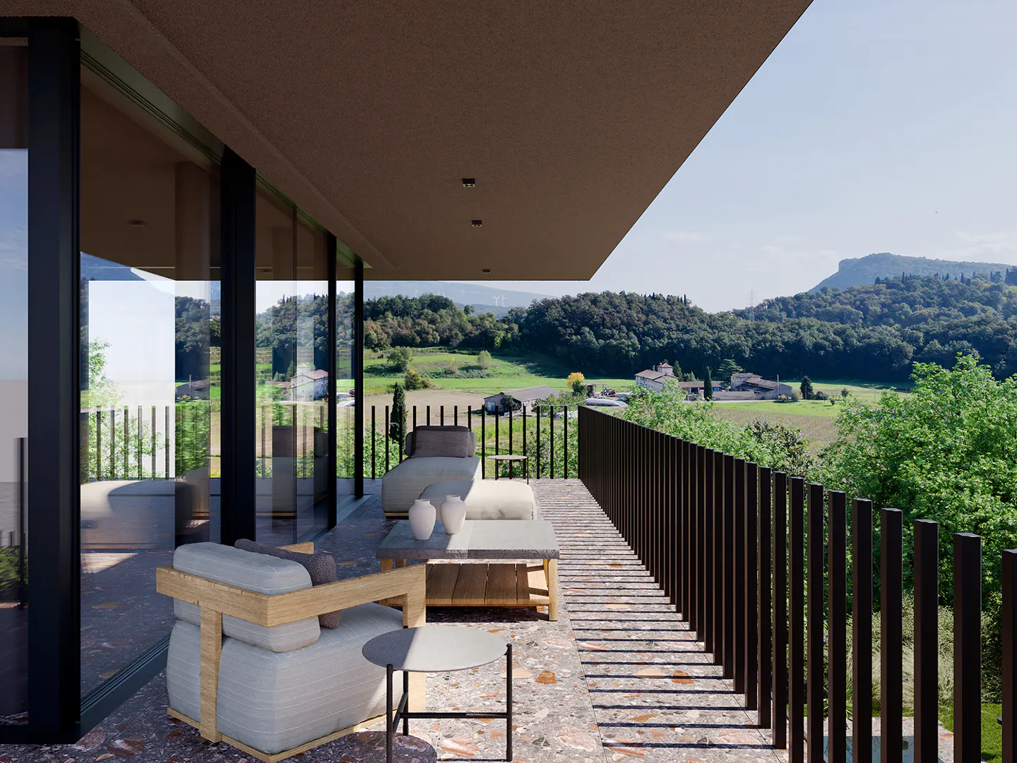 A modern balcony with outdoor furniture overlooks a green landscape. The balcony has a brown railing and a terrazzo floor.