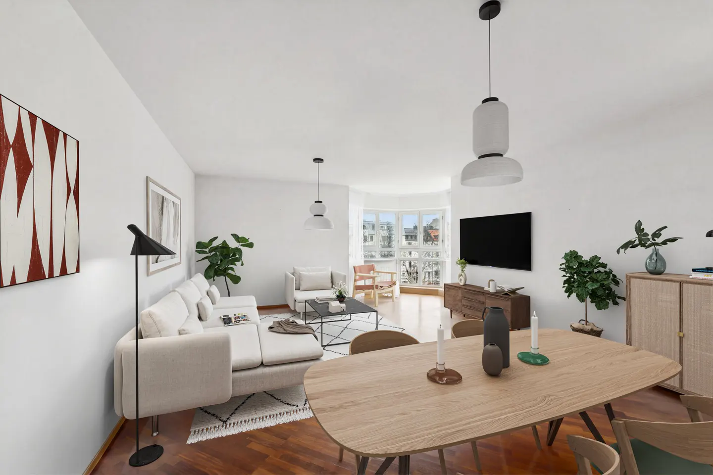 Bright, modern living room with white walls, wood floors, and a large window. A white sectional sofa faces a TV. A wood dining table sits in the foreground.