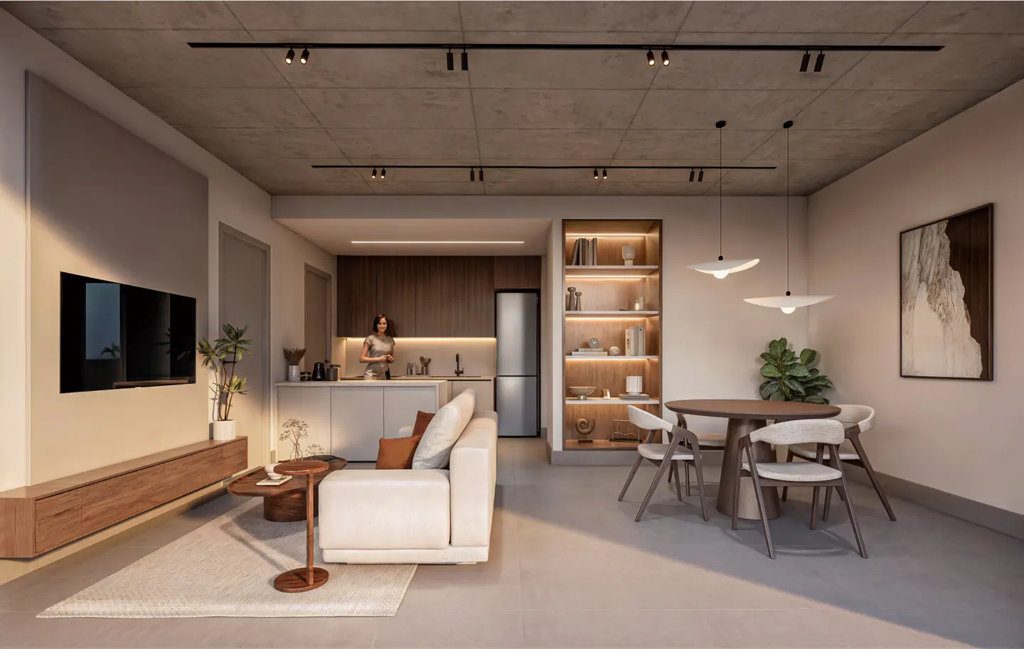 A modern apartment interior with a white sofa, dining table, and a woman in the kitchen.