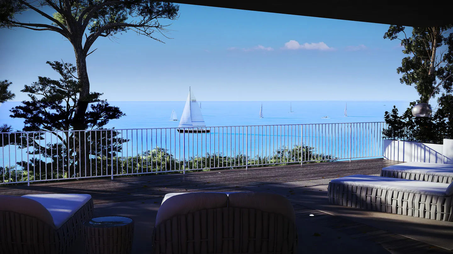 Ocean view from a patio with white lounge chairs and a white railing. Sailboats are visible on the blue water.