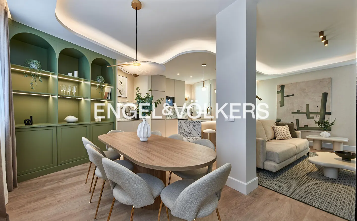 Modern dining area with oval wood table, light gray chairs, and sage green arched shelving, opening into a living room.