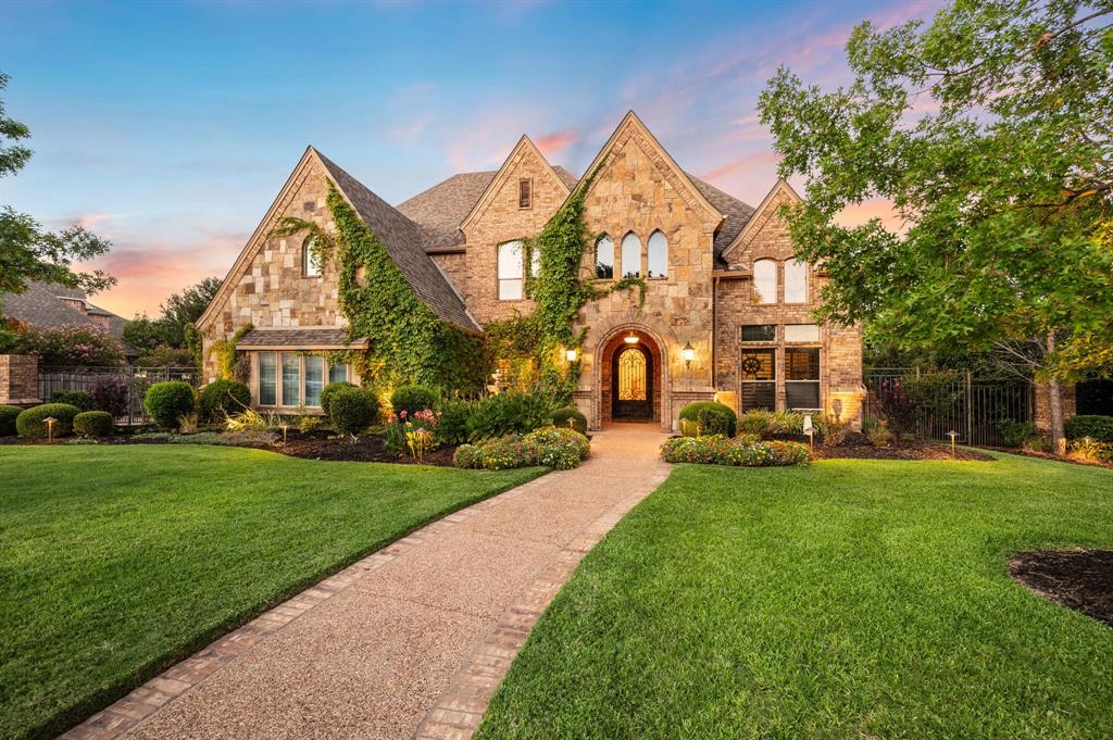 Stone mansion with ivy-covered facade, arched entryway, and manicured lawn under a sunset sky. [AI-generated text]