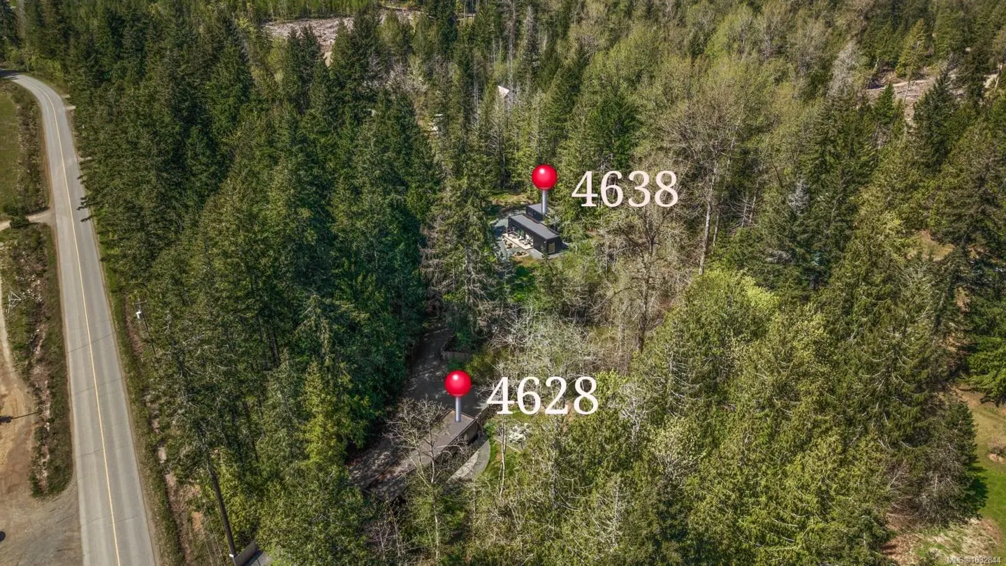 Aerial view of two houses, 4628 and 4638, nestled in a dense green forest near a road. Red pins mark the house locations.