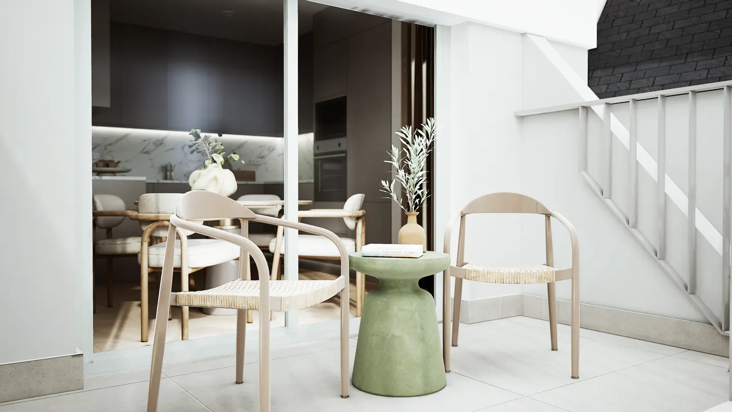 A bright balcony with two beige chairs and a green side table. A vase with olive branches sits on the table. The open sliding door reveals a modern kitchen.