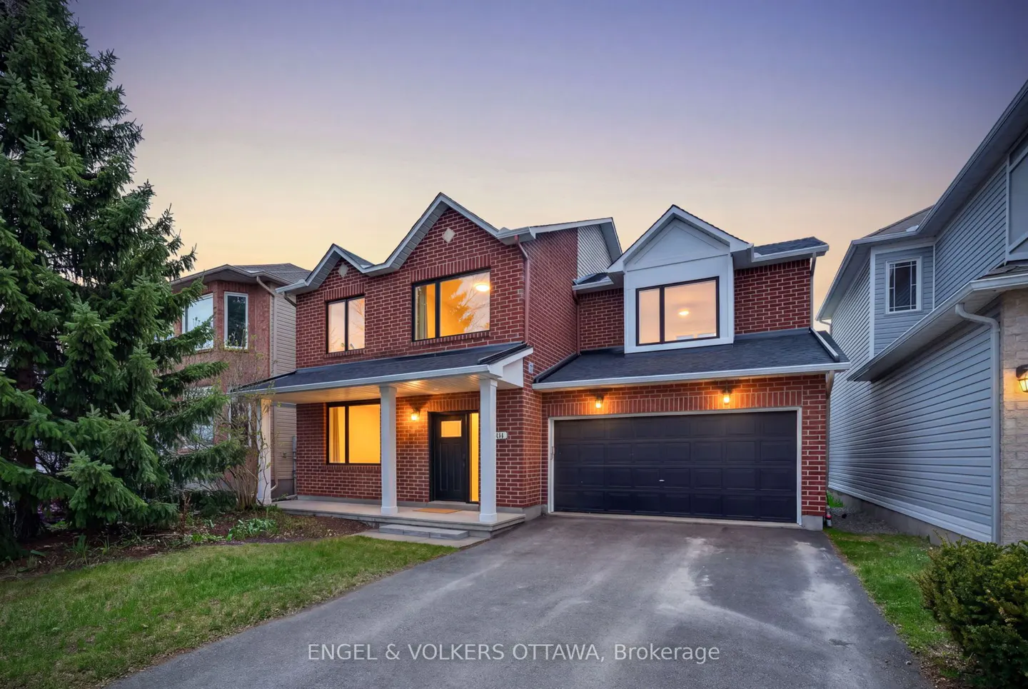 Two-story brick house with a black garage door and white trim, set against a twilight sky.