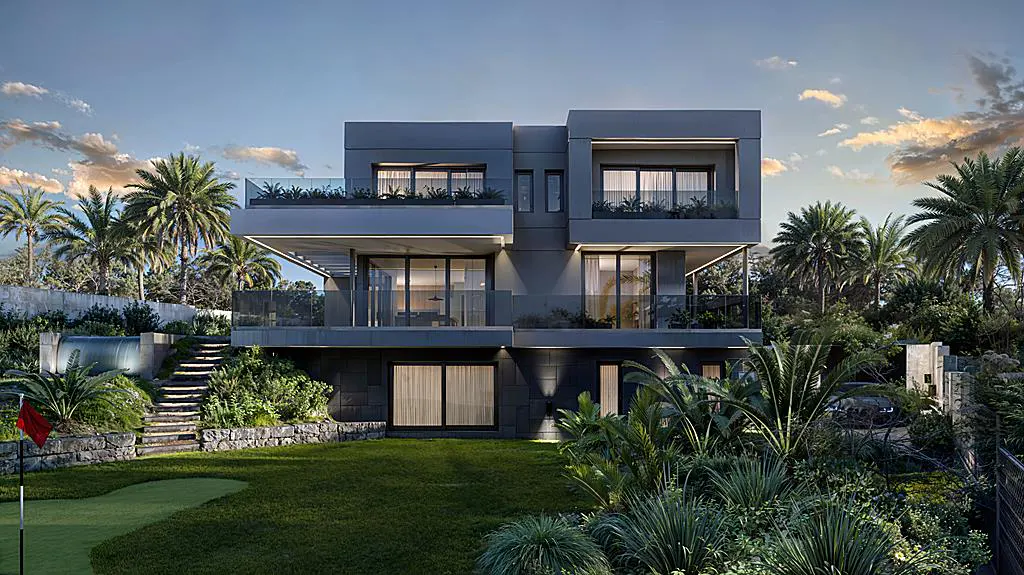 Modern gray two-story house with glass balconies, surrounded by lush green landscaping and palm trees. A putting green is in the foreground.