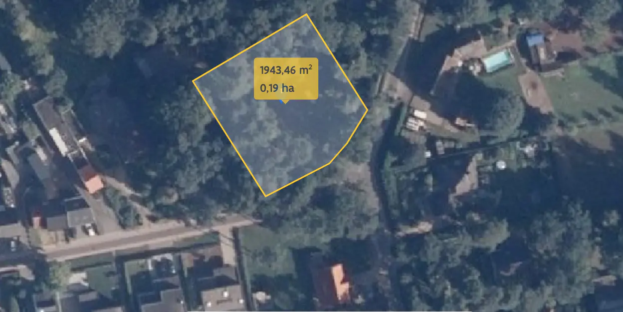 Aerial view of a 1943.46 square meter lot outlined in yellow, surrounded by trees and houses in a residential area.