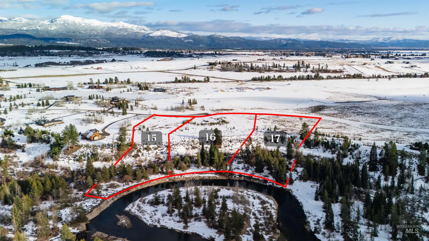 Aerial view of snowy land plots 15, 16, and 17, outlined in red, near a river and mountains.